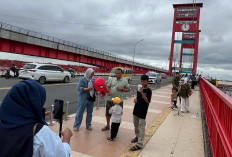 Wisatawan Antusias Berpose di Ampera