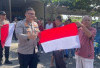 Polres OKU Bagikan Bendera Merah Putih ke Warga